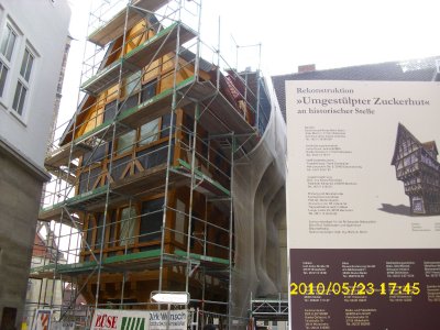 Farbfoto: Der Nachbau von dem Fachwerkhaus Umgestülpter Zuckerhut in Hildesheim im Jahre 2010. Links neben dem Umgestülpten Zuckerhut Blick auf die Andreaskirche im Bildhintergrund. Fotograf: Kim Hartley.