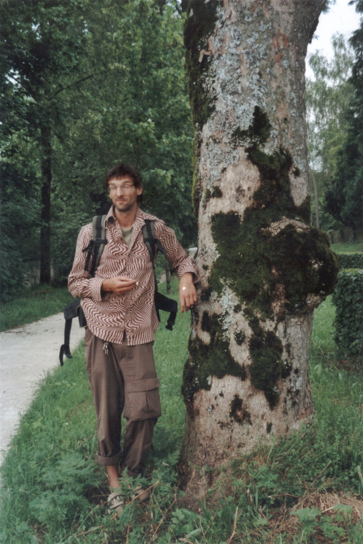 Photo von Ralf Splettstößer neben einem mit Moos, Algen und Flechten bewachsenen Baumstamm an der  Kardinal-Faulhaber-Straße in Traunstein in Oberbayern aus dem Jahr 2006. Photo: Erwin Thomasius